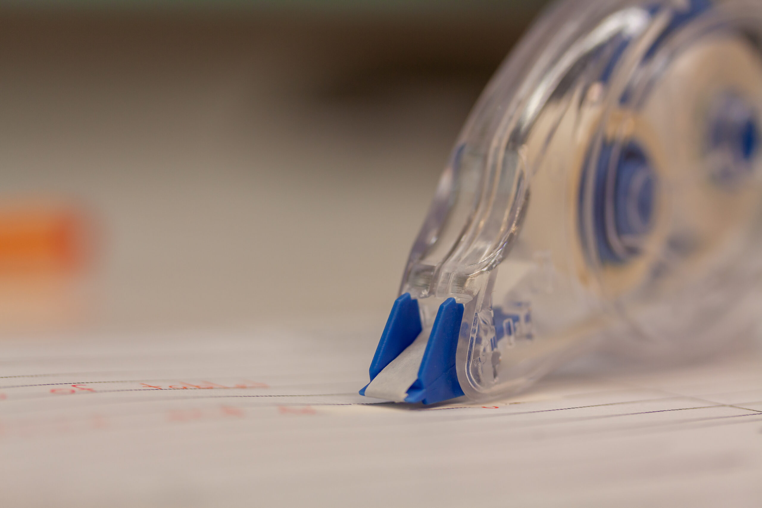 Closeup view of a correction tape to delete written text on a piece of